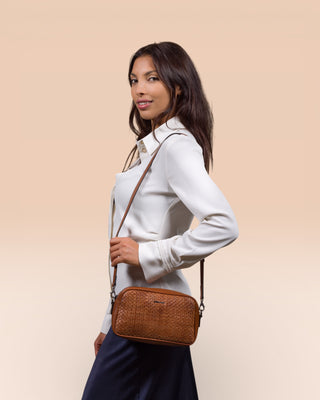 Model wearing Afef Medium cuoio leather crossbody bag by Benheart, profile pose, bag front view with shoulder strap.