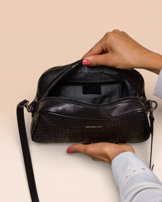 Benheart Afef Medium leather crossbody bag in Black color, held open by model to showcase interior compartments and leather details.