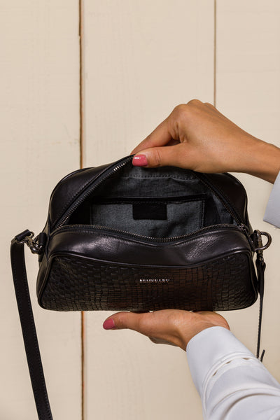 Benheart Afef Medium leather crossbody bag in Black color, held open by model to showcase interior compartments and leather details.