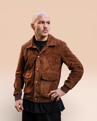 Half-body shot of a model wearing a suede jacket by Benheart, entirely handmade in Italy.
