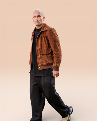 Full-body shot of a model in motion, wearing an open suede jacket by Benheart
