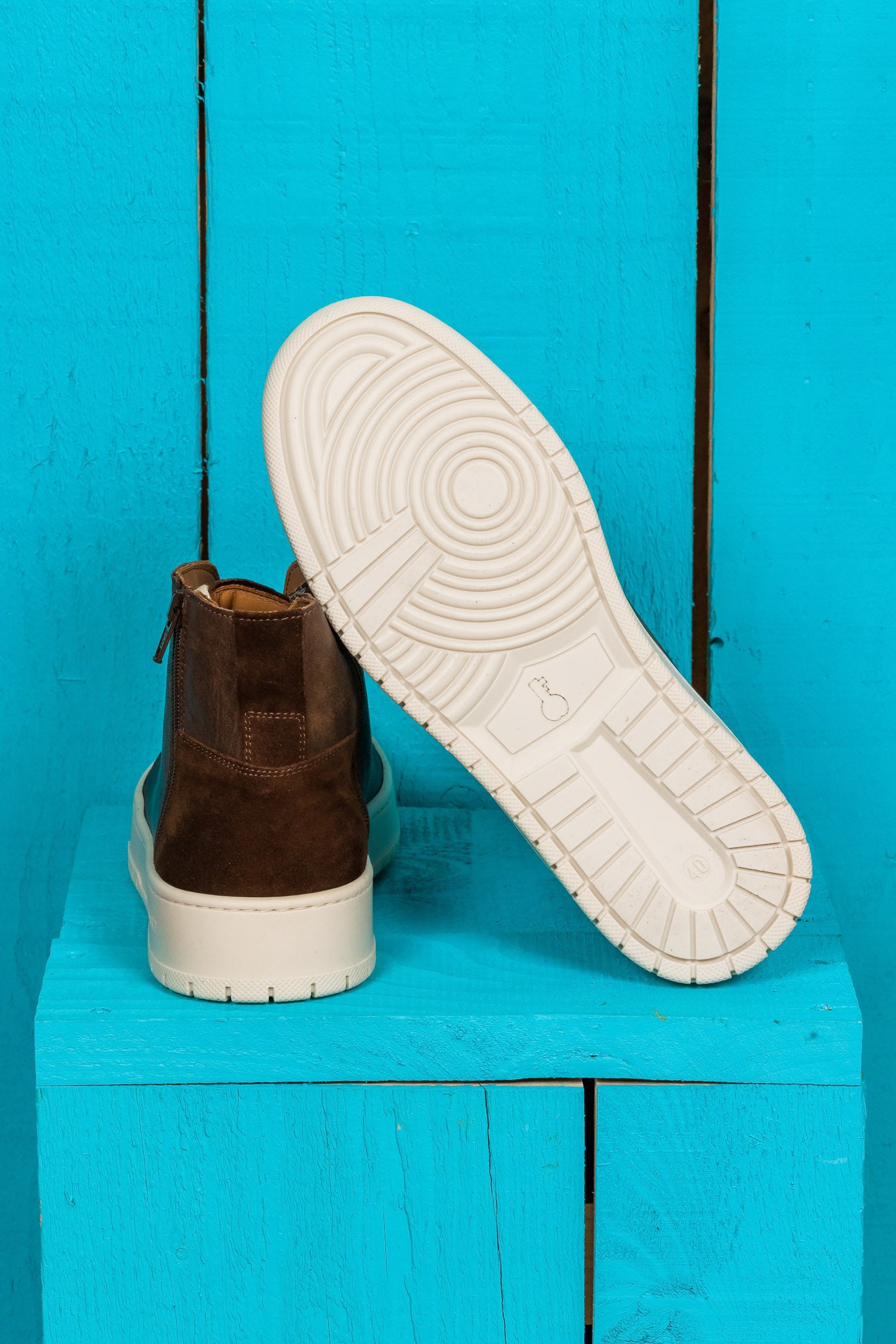 Rear view of one Bonetti 8473 unisex brown leather high-top sneaker, while the other is angled to display the rubber sole.
