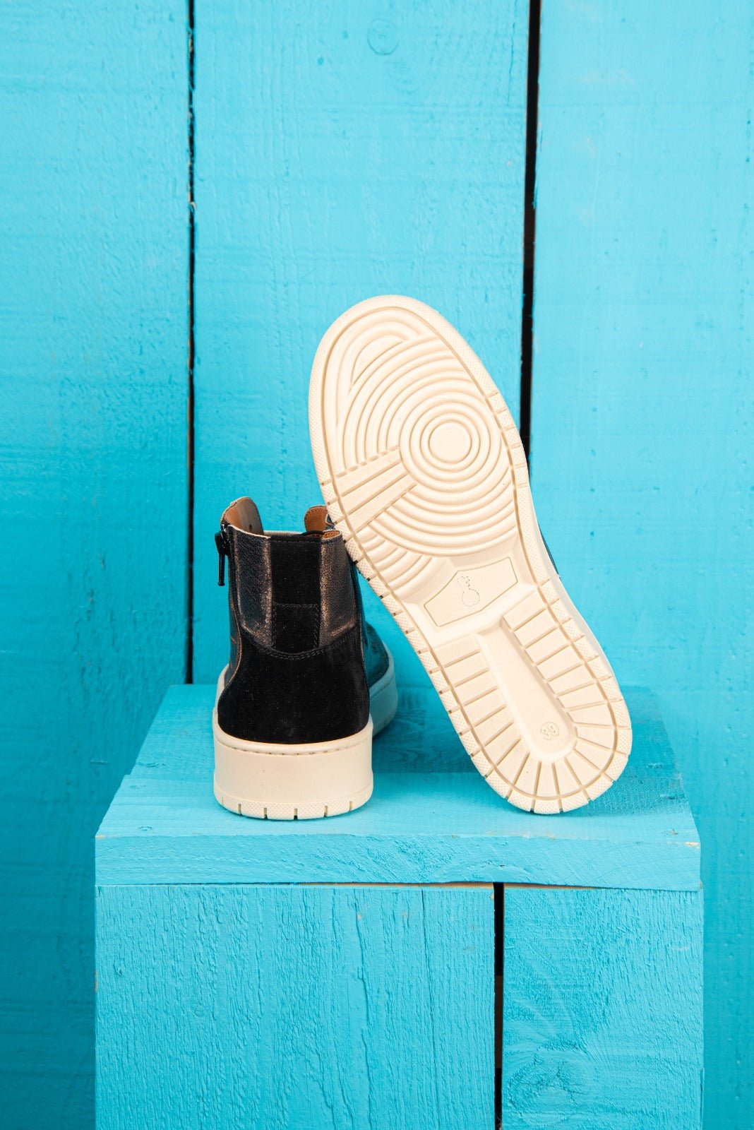 Rear view of one Bonetti 8473 unisex black beige leather high-top sneaker, while the other is angled