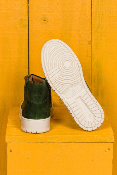 Rear view of one Bonetti 8473 unisex green leather high-top sneaker, while the other is angled to display the rubber sole.