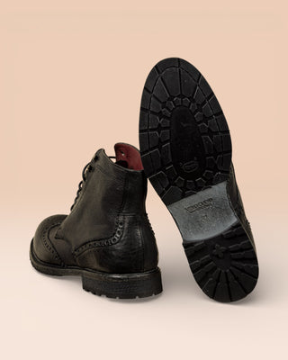 Detail of the Vibram sole of a pair of Benheart Daniel men’s black leather lace-up brogue ankle boots with wingtip design