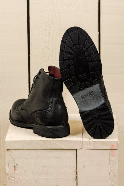 Detail of the Vibram sole of a pair of Benheart Daniel men’s black leather lace-up brogue ankle boots with wingtip design