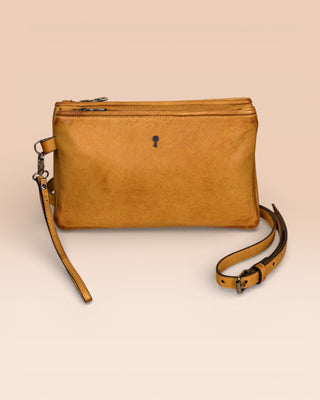Front view of the Benheart Desert Pochette leather clutch in mahogany, highlighting the two zippered compartments and adjustable shoulder strap.