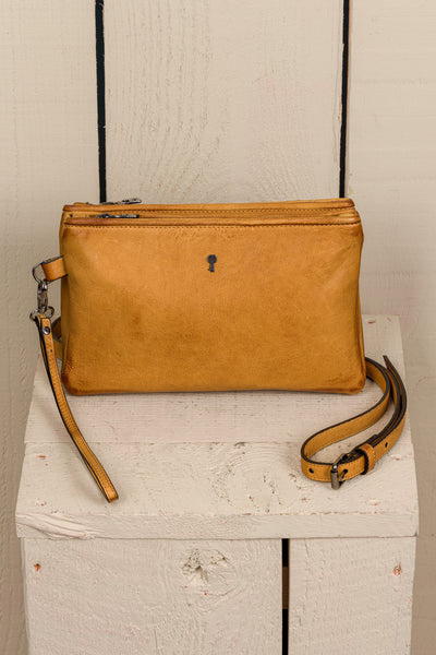 Front view of the Benheart Desert Pochette leather clutch in mahogany, highlighting the two zippered compartments and adjustable shoulder strap.