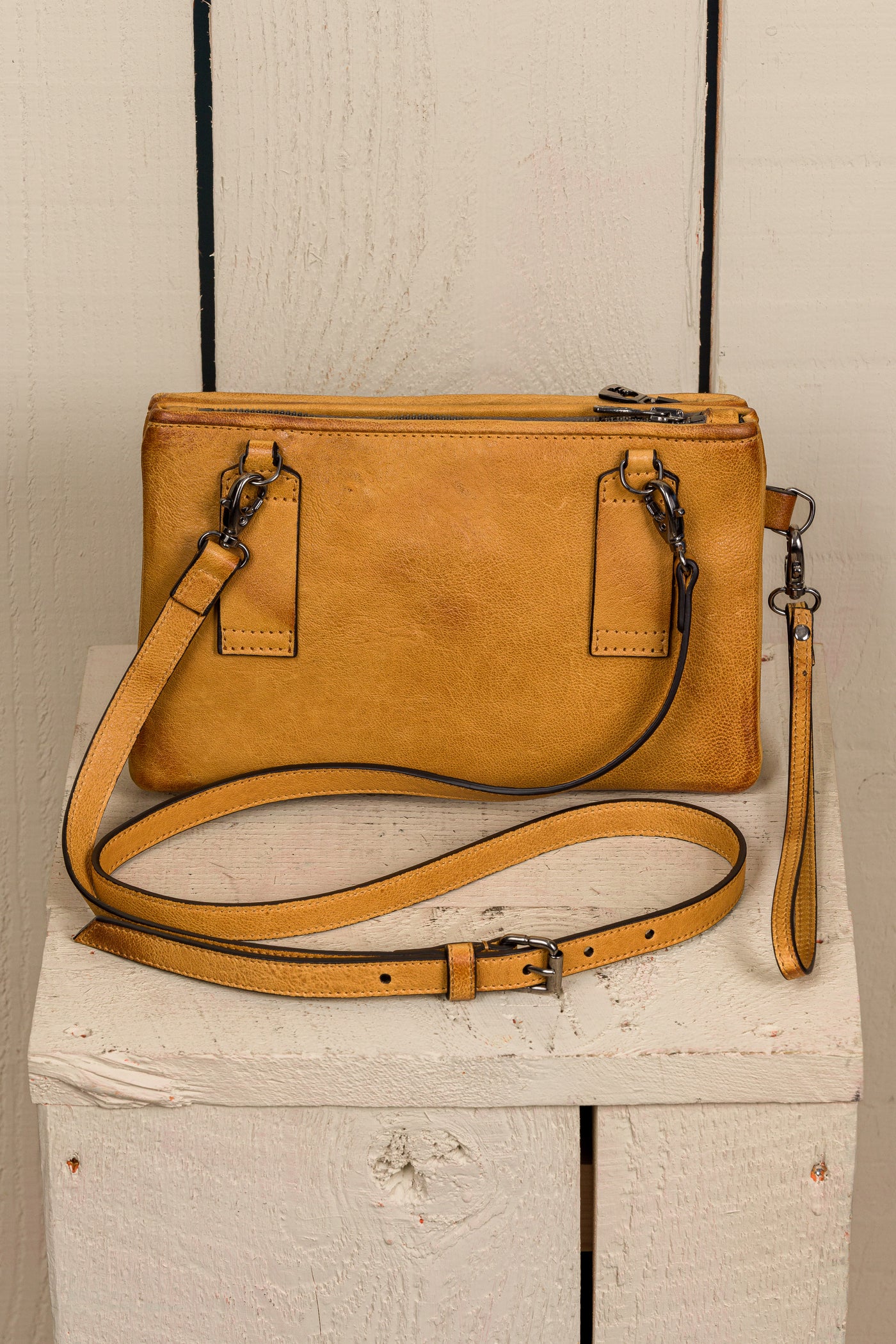 Back view of the Benheart Desert Pochette leather clutch in mahogany, showing the adjustable shoulder strap and smooth leather finish.