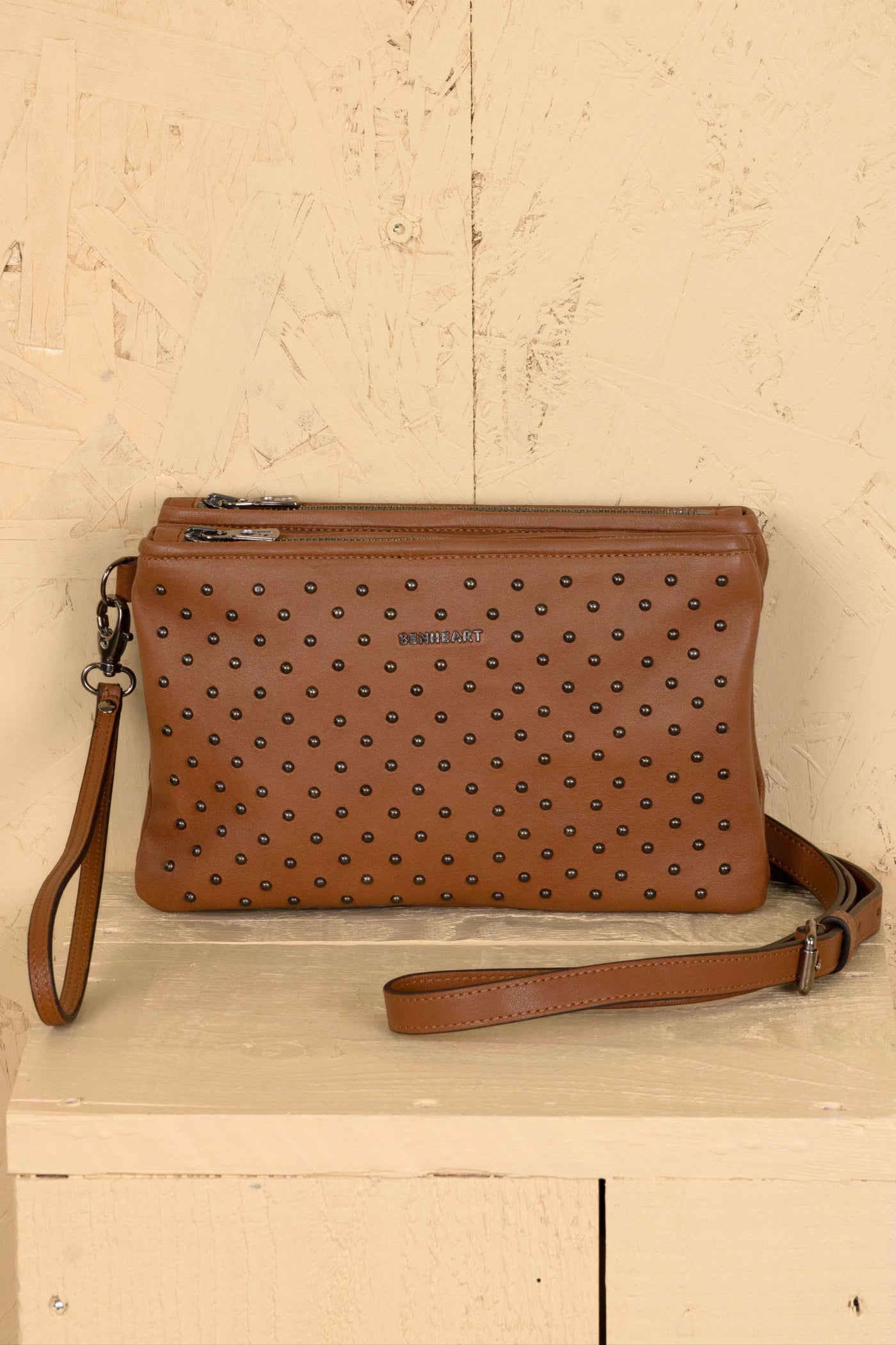 Front view of the Benheart Desert Pochette Borchiata in Cuoio color, slightly angled to show the two zip pockets