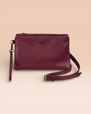 Front view of the Benheart Desert Pochette leather clutch in prugna, highlighting the two zippered compartments and adjustable shoulder strap.