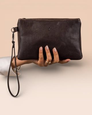 Front view of the Benheart Desert Pochette leather clutch in dark brown held in hand by a model, compact size, handcrafted in Italy.