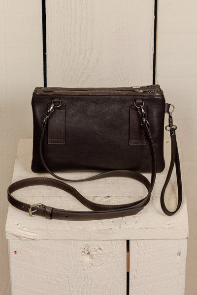 Back view of the Benheart Desert Pochette leather clutch in dark brown, showing the adjustable shoulder strap and smooth leather finish.