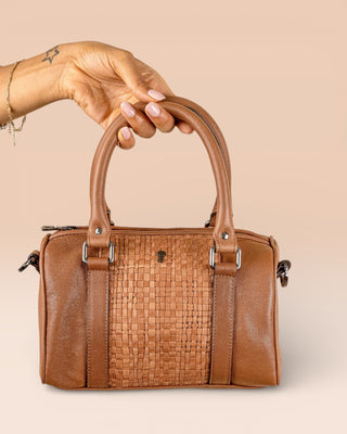 Front view of Benheart Dom Intrecciata tan woven leather bag, held by model on handles, handcrafted in Florence.
