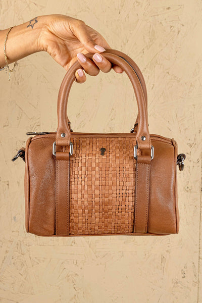 Front view of Benheart Dom Intrecciata tan woven leather bag, held by model on handles, handcrafted in Florence.