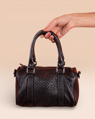 Front view of Benheart Dom Intrecciata black woven leather bag, held by model on handles, handcrafted in Florence.