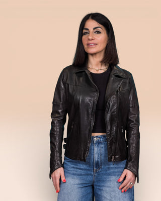 Model wearing Fede black women's leather biker jacket, open, front view.