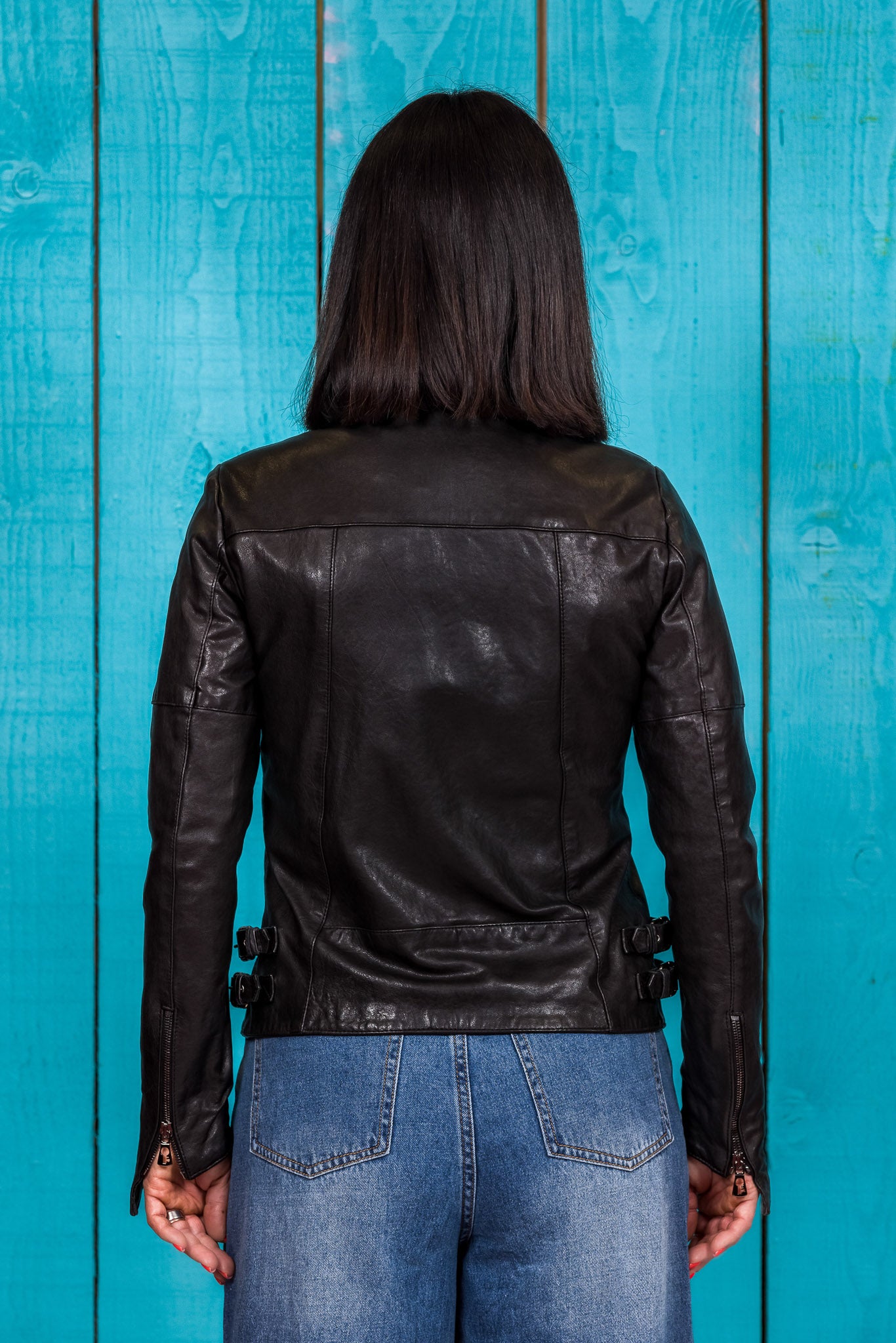 Rear view of model in Fede women's black leather jacket.
