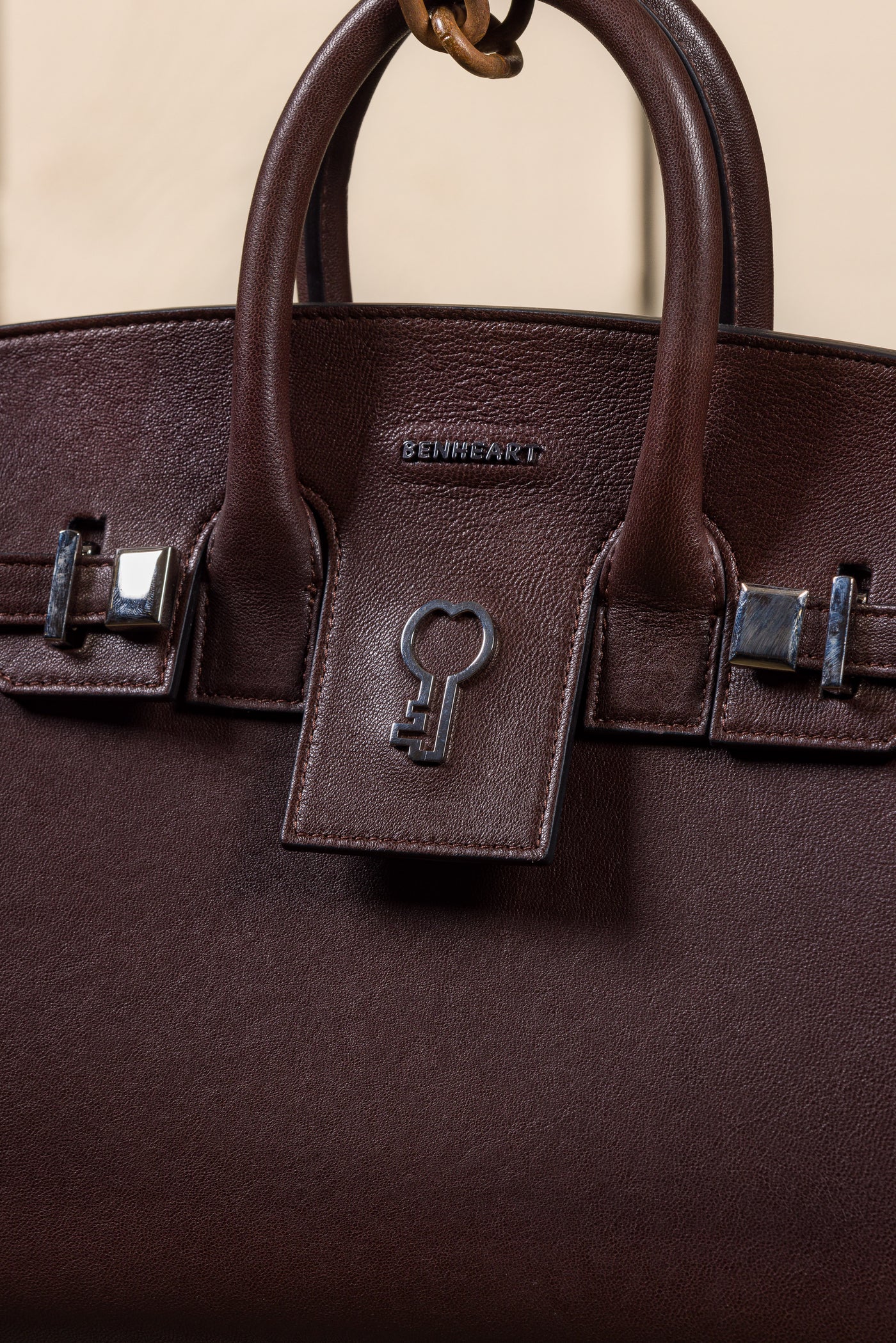Close-up of Ginevra Small chocolate lambskin bag with Benheart logo.