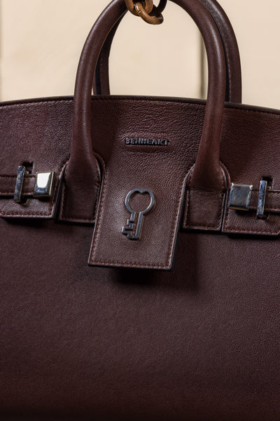 Close-up of Ginevra Small chocolate lambskin bag with Benheart logo.