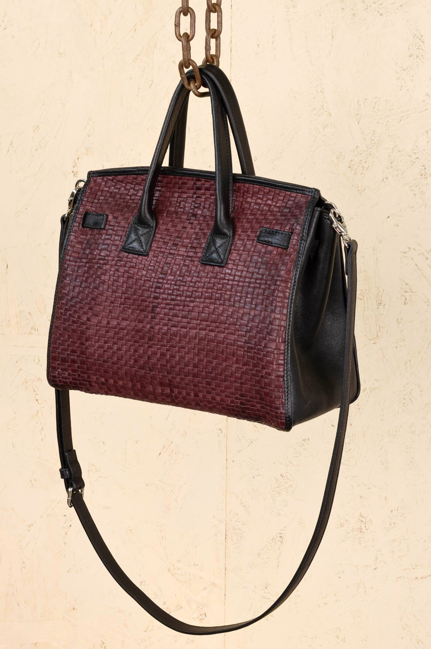 Rear angled view of Benheart Ginevra Small Intrecciata woven lamb leather bag in plum.