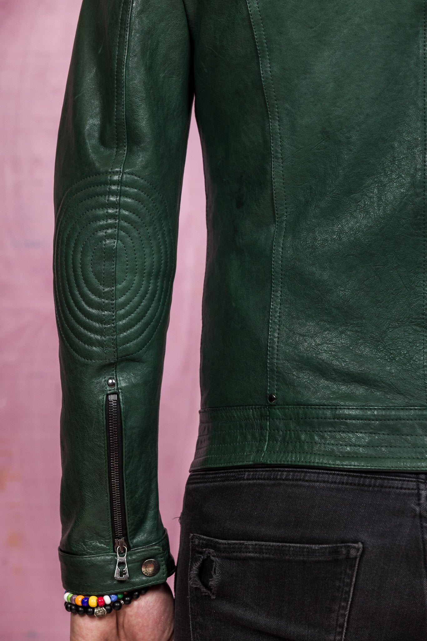 Close-up of the left sleeve of the green High Limited leather jacket by Benheart, showing zipper detail.