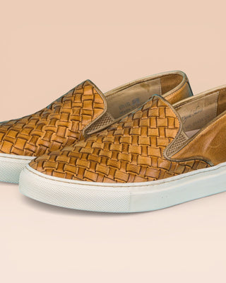 Close up view of Iris unisex woven slip-on shoes in mahogany leather with white rubber soles.