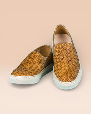 Front angled and top view of Iris unisex woven slip-on shoes in mahogany leather with white rubber soles.