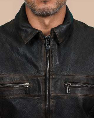 Close-up of the model wearing the black James Special leather jacket by Benheart, highlighting the detailed zippers and pocket hardware.
