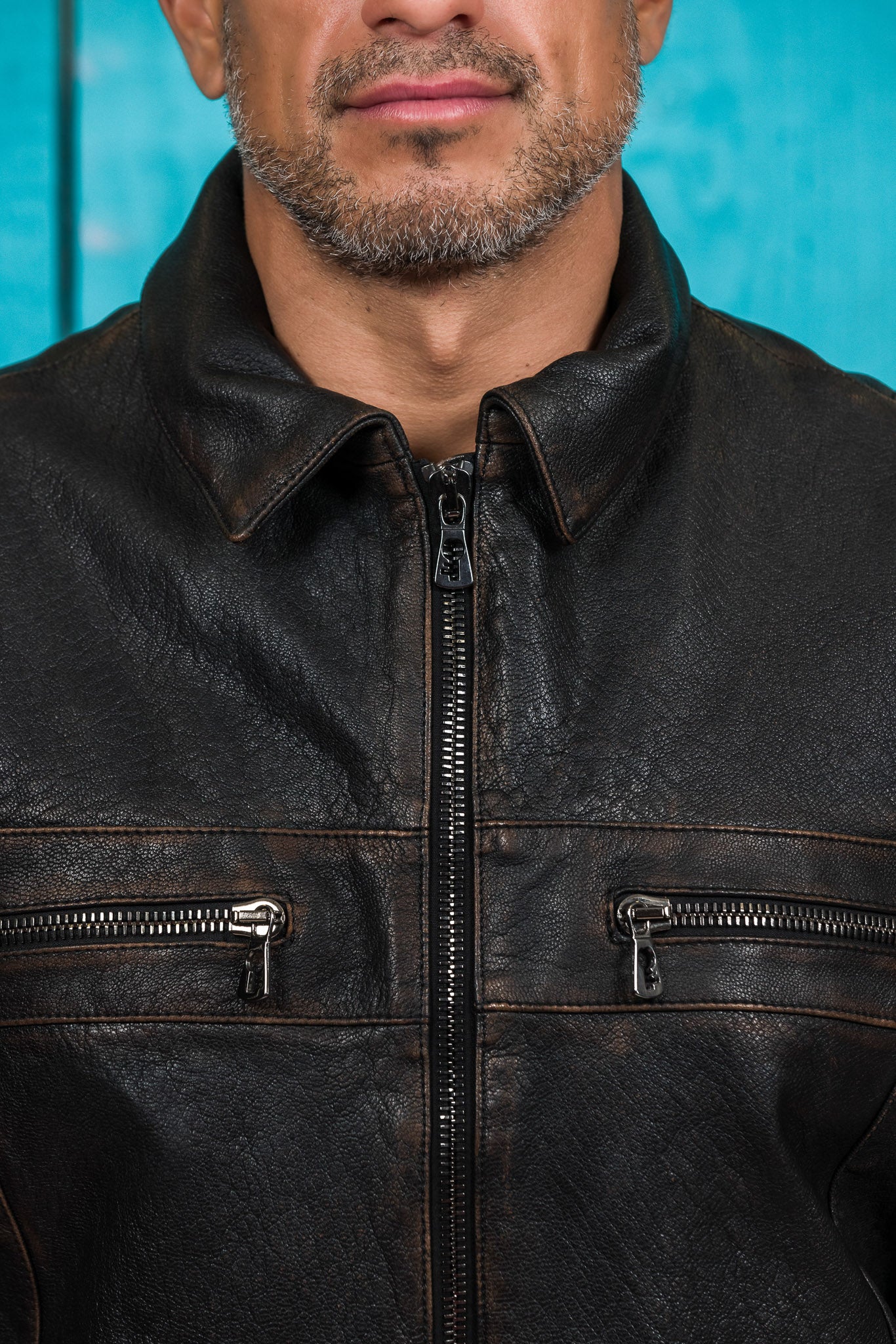 Close-up of the model wearing the black James Special leather jacket by Benheart, highlighting the detailed zippers and pocket hardware.