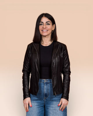 Front view of model wearing Jane women's black leather biker jacket, jacket open.