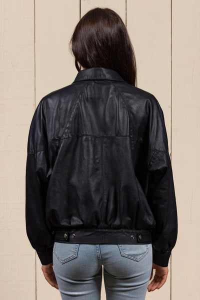 Rear view of a model wearing the Jasmine oversized black leather jacket for women.