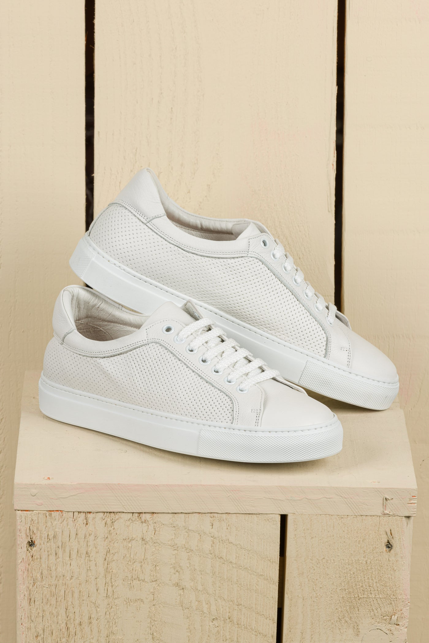 Side angled view of Benheart Lario unisex perforated leather sneakers shoes in white color.