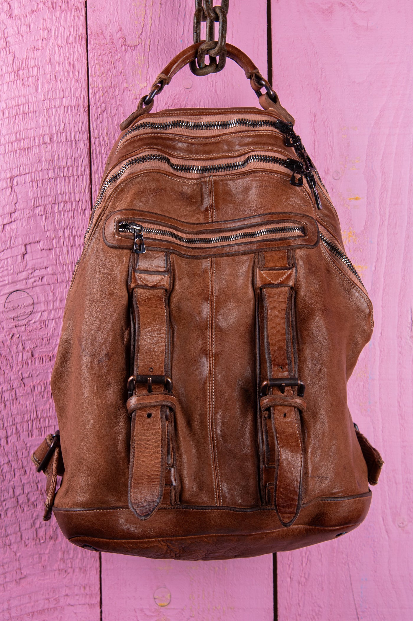 Front view of the Lorenzo unisex leather backpack in cuoio, showing front pockets and zipper details, handcrafted in Italy.