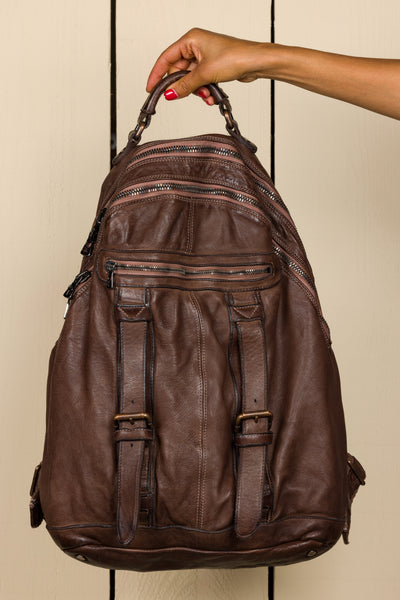Model holding the Lorenzo unisex leather backpack in brown by Benheart.