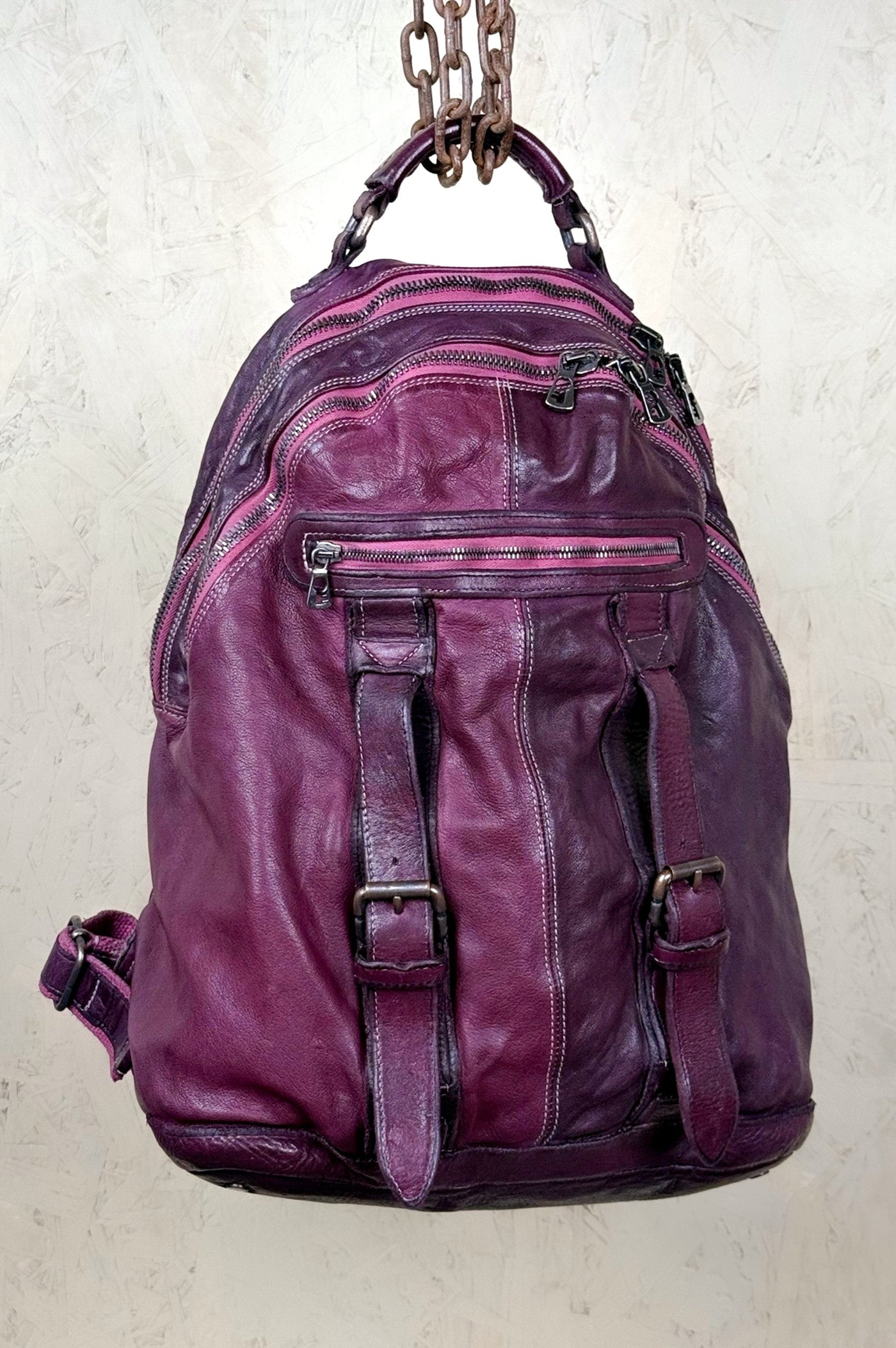 Lorenzo unisex leather backpack by Benheart in plum, showing front pockets and zipper details, front view.