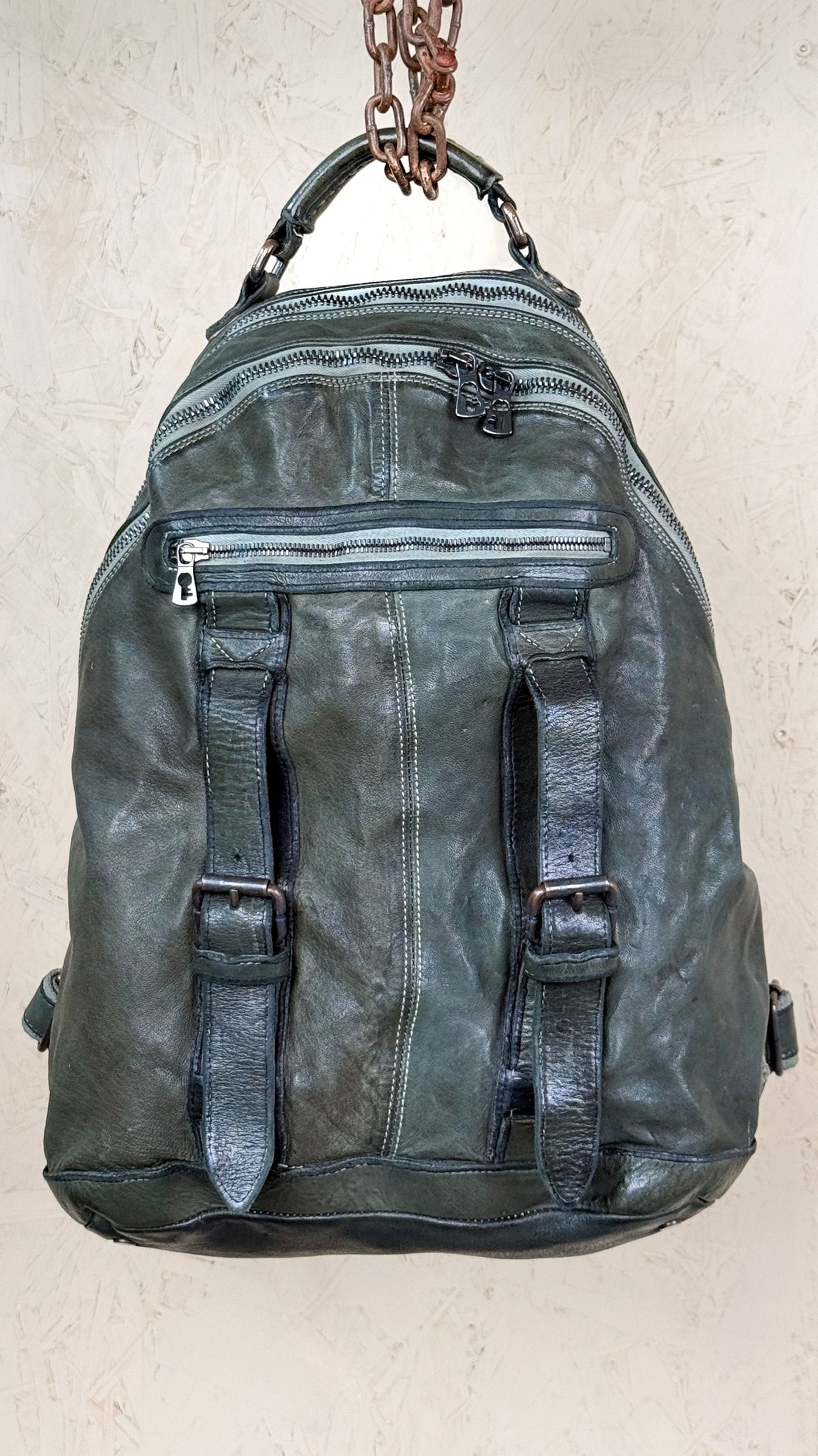 Lorenzo unisex leather backpack by Benheart in green, showing front pockets and zipper details, front view.