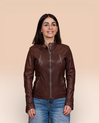 Front view of model in Lory women's brown leather biker jacket, worn closed.