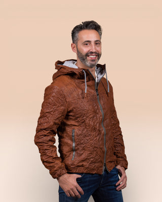 Angled view of a model wearing the Michelangelo men's leather jacket in cognac, with the collar open, featuring visible zippers and hood drawstrings.