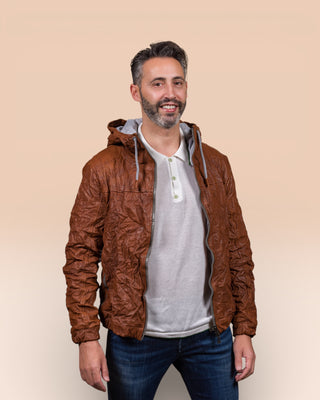 Model wearing a Michelangelo men's leather jacket with hood, in cognac leather, handcrafted by Benheart in Florence, Italy, with the jacket open.