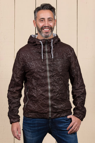 Model wearing a Michelangelo men's leather jacket with hood, in dark brown, handcrafted by Benheart in Florence, Italy.
