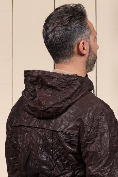 Detail of the model wearing the Michelangelo men's leather jacket in dark brown, rear view highlighting the hood.