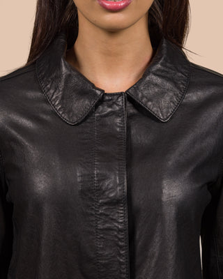 Close-up of a model wearing the Mini black leather jacket, fully buttoned.