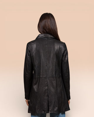 Rear view of a model wearing the Mini black leather jacket for women, handcrafted in Florence, Italy.