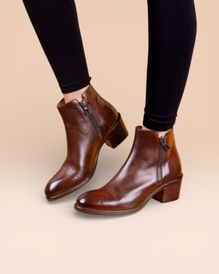 Model wearing a pair of Benheart Miranda 5258 women’s brandy leather ankle boots with side zip.