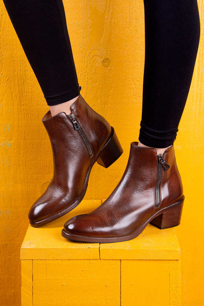Model wearing a pair of Benheart Miranda 5258 women’s brandy leather ankle boots with side zip.