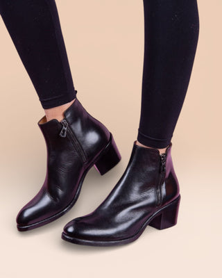 Model wearing a pair of Benheart Miranda 5258 women’s black leather ankle boots with side zip.