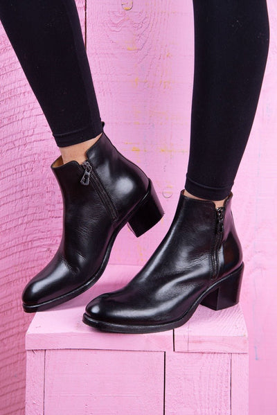 Model wearing a pair of Benheart Miranda 5258 women’s black leather ankle boots with side zip.