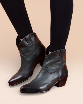Benheart Natali 5151 women's leather Texan low-cut boots in dark green, worn by a model on an orange surface.