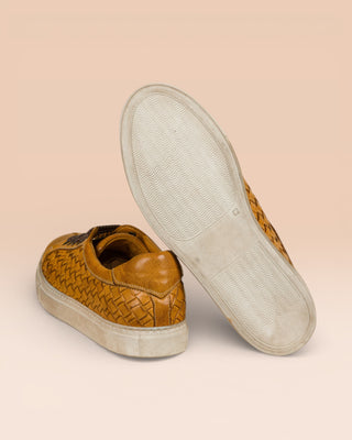 Rear view of Oliviero 6201 men's mahogany woven leather low-top sneakers by Benheart, close-up of white rubber soles.